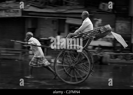 Uomo tirato in rickshaw con passeggero, Calcutta, West Bengal, India Foto Stock