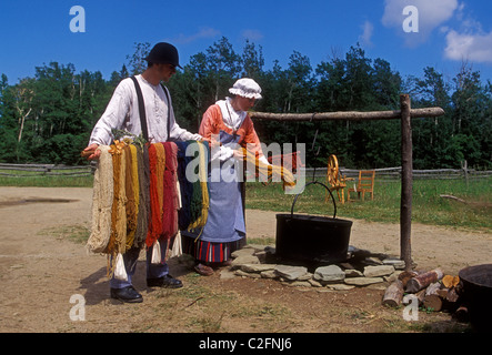 Donna canadese, uomo canadese, la tintura di lana, indossando il costume, Acadian Historical Village, vicino alla città di Caraquet, New Brunswick Provincia, Canada Foto Stock