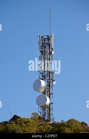 Una torre di telecomunicazioni con piatti a microonde e antenne di telefonia mobile Foto Stock