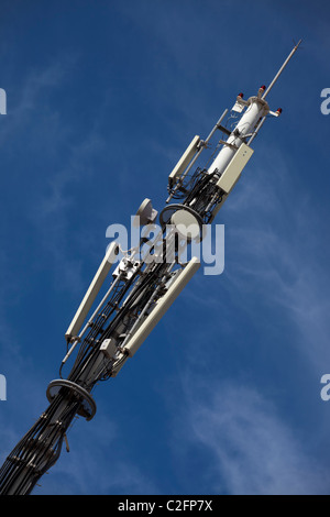 Una torre di telecomunicazioni con piatti a microonde e antenne di telefonia mobile Foto Stock