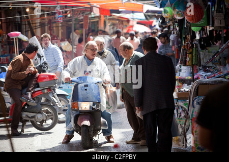 Un uomo su uno scooter prende il suo modo attraverso il mercato Ballaro (mercato) Palermo Sicilia Italia Foto Stock