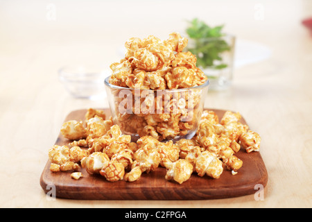 Ciotola di vetro di popcorn rivestita con caramello Foto Stock