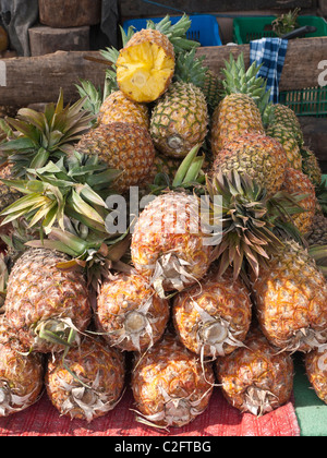 Ananassi freschi vengono impilati fino a un fornitore in stallo per la vendita nel mercato pubblico in Antigua, Guatemala. Foto Stock