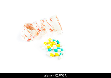 Foto di pillole e nastro di misurazione isolata su bianco Foto Stock