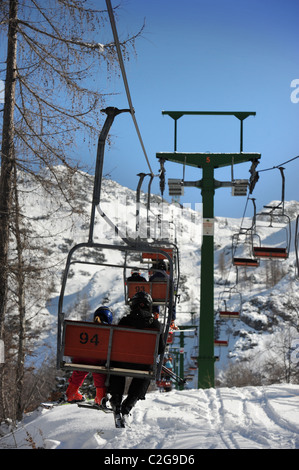 Gli sciatori in seggiovia al Vogel Ski Center dalla base del Sija - Zadnji Vogel piste del Parco Nazionale del Triglav di Slo Foto Stock