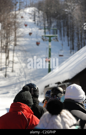 Gli sciatori in coda per una seggiovia a Vogel Ski Center sul Sija - Zadnji Vogel piste del Parco Nazionale del Triglav di Sloven Foto Stock