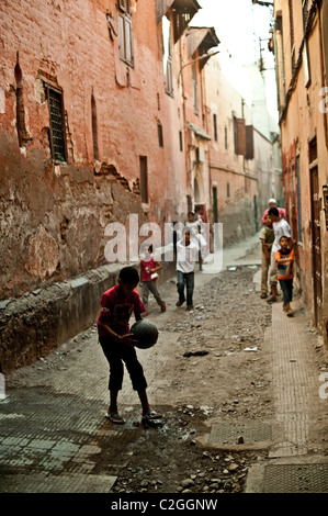 Ragazzi che giocano a calcio in un vicolo a Marrakech Foto Stock