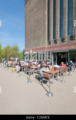 Dinning persone fuori nel sole di primavera presso la galleria d'arte Tate Modern accanto al fiume Tamigi a Londra, Inghilterra, Regno Unito. Foto Stock