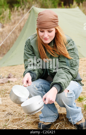 Tenda da campeggio donna felice lavaggio piatti in natura Foto Stock