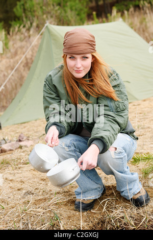 Tenda da campeggio donna felice lavaggio piatti in natura Foto Stock