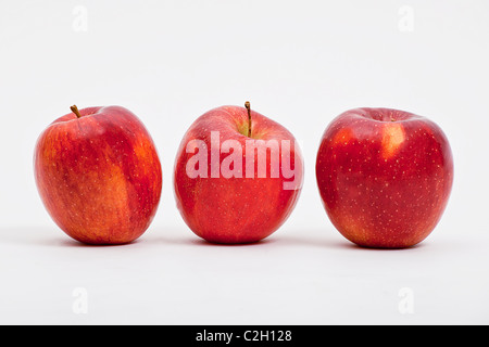 Tre fresche Mele rosse su sfondo bianco Foto Stock