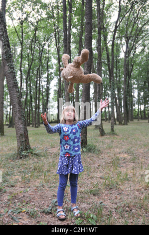 Un bambino di 8 anni bambino getta la sua recare nel bosco Foto Stock