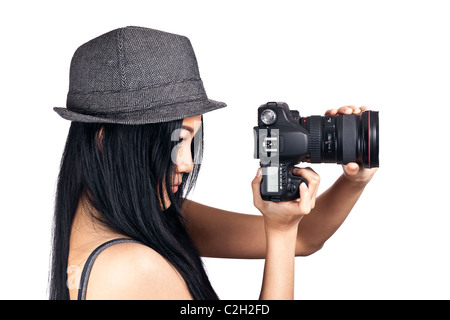 Una giovane ragazza asiatica di guardare attraverso il mirino di una reflex digitale e sempre pronto a scattare una foto. Foto Stock