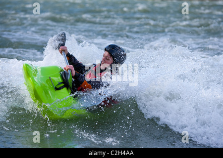Playboating femmina whitewater kayaker nel giro stretto surf sulle onde, Rhone river vicino a Lione, Sault Brenaz, Francia Foto Stock