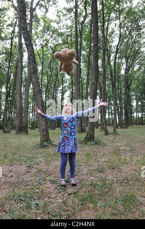 Un bambino di 8 anni bambino getta la sua recare nel bosco Foto Stock