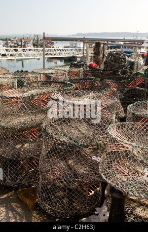 Barche da pesca Poole Harbour con attività di pesca del granchio pentole in primo piano. Foto Stock