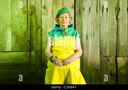 86 anni donna elegante è seduto sulla sedia. Guardando nella parte anteriore della fotocamera. Foto Stock