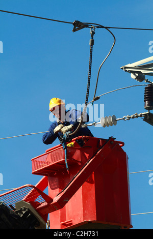 Elettricista lavorando sulla sommità di una torre Foto Stock