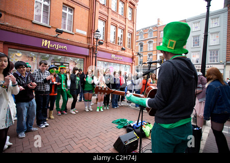 Il giorno di San Patrizio festaioli di Grafton Street, Dublin, Irlanda la visione di una banda che suona musica e cantare alcune canzoni Foto Stock