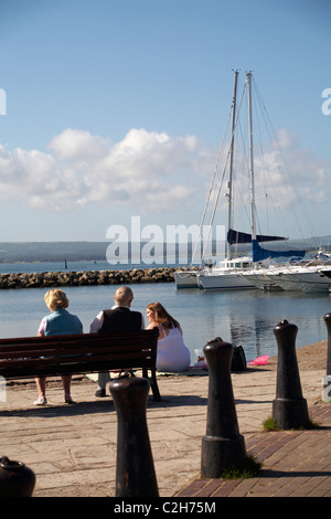 Sat godendo di viste sul porto di Poole nel mese di agosto Foto Stock