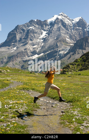 Una donna che si tuffa in un torrente di montagna, Lauterbrunnental, Svizzera Foto Stock