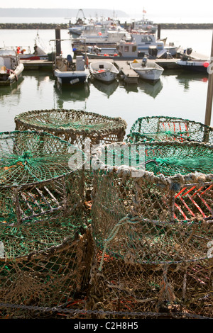 Barche da pesca Poole Harbour con attività di pesca del granchio pentole in primo piano. Foto Stock