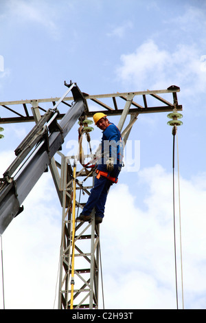 Elettricista lavorando sulla sommità di una torre Foto Stock