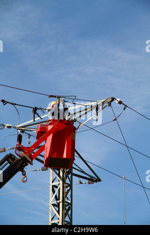 Elettricista lavorando sulla sommità di una torre Foto Stock