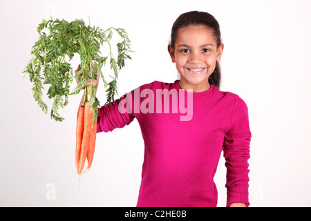 Sorridente ragazza afro-americano tenendo in mano un mazzo di carote Foto Stock