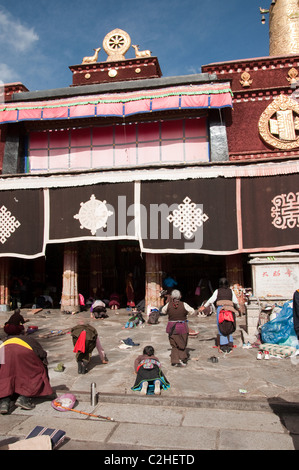 Pellegrini prosternerà fuori il tempio del Jokhang, Tibet Foto Stock