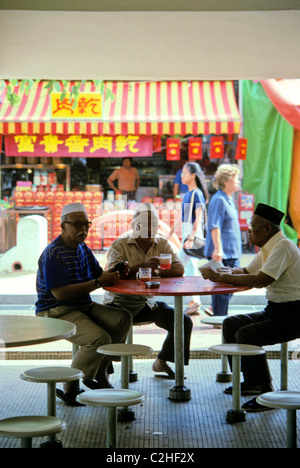 Tre anziani pensionati uomini bere il caffè a Singapore Food Court coffee shop Foto Stock