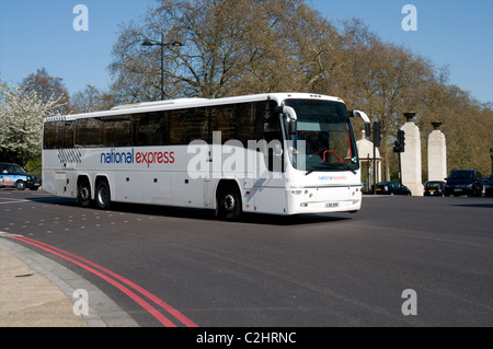 Un National Express assale tre turni in autobus da Hyde Park Corner sul suo cammino verso la stazione dei pullman di Victoria Foto Stock