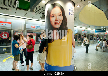 La pubblicità che colpisce in Singapore Mass Rapid Transit (MRT) sistema di metropolitana. Qui alla stazione Orchard sulla linea nord-sud Foto Stock