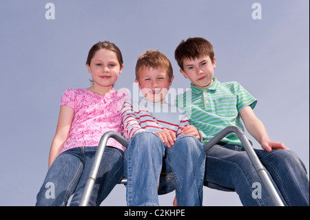 Un modello rilasciato foto di una ragazza e due ragazzi ( 7 , 9 , e 11 ) all'aperto su un telaio di arrampicata nel Regno Unito Foto Stock