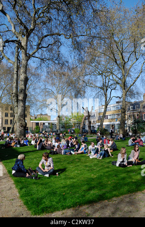 Giovani godendo il sole in Hoxton Square, Londra, Inghilterra Foto Stock