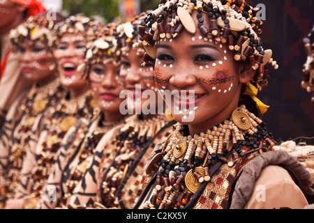 Una linea di donne in costumi a perline e perle abiti di testa. Foto Stock