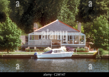 Una piccola barca a motore ormeggiata presso un riverside house sul Fiume Tamigi vicino a Henley on Thames Oxfordshire England Regno Unito Foto Stock