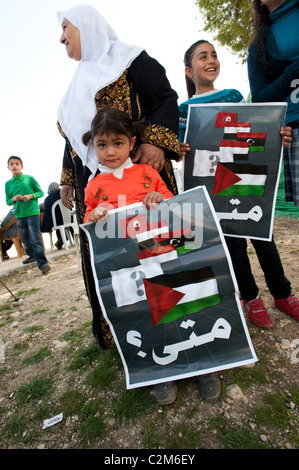 Bambini palestinesi tenere segni con le bandiere della Tunisia, Egitto, Libia, Yemen, Palestina e la questione in arabo: "Quando?". Foto Stock