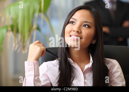 Ritratto di una giovane bella donna asiatica in un ambiente aziendale Foto Stock