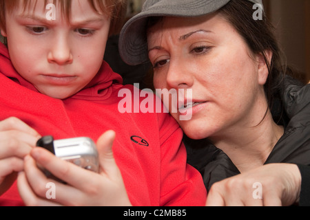 Madre e figlio di 39 anni e 8 Riproduzione di un computer palmare video gioco. Clitherall Minnesota MN USA Foto Stock