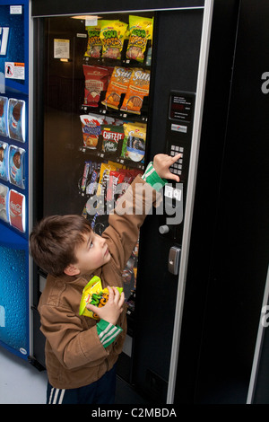 Età bambino 5 lavora il candy da gettoni macchina distributrice. St Paul Minnesota MN USA Foto Stock