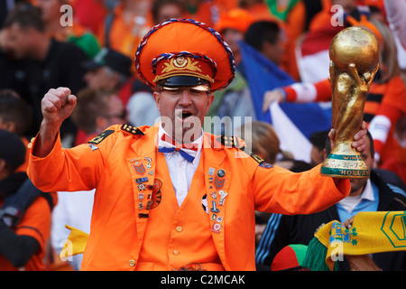 Un sostenitore Holland cheers tenendo una replica trofeo a un 2010 Coppa del mondo partita di calcio tra i Paesi Bassi e la Danimarca Foto Stock