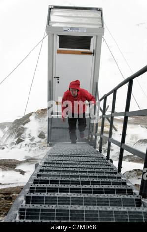 Una ski tourer di ritorno dalla toilette esterna presso il rifugio Nacamuli, Val d'Aosta, Alpi Italiane. Foto Stock