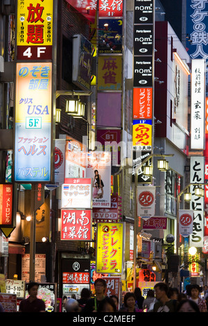 Una strada laterale nel trafficato quartiere di Shinjuku, piena di colorati segni e pubblicità, Tokyo, Giappone. Foto Stock