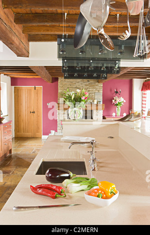 Fattoria tradizionale cucina con esposti woodenbeams, utensili da appendere e bianco stampato a piani di lavoro Foto Stock