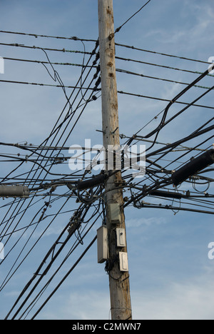 Linee di alimentazione aeree. Confuso di fasci di cavi elettrici sospesi su un polo utilità. Long Island, Queens, a New York Foto Stock