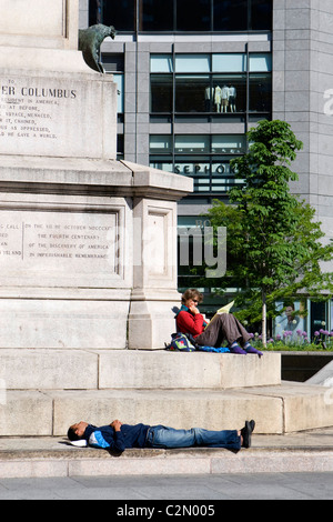 Persone rilassante sulla base del Christopher Columbus statua Foto Stock