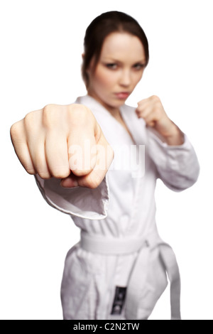 Messa a fuoco basso isolato ritratto di belle arti marziali ragazza in kimono excercising karate kata. focus sul pugno. Foto Stock