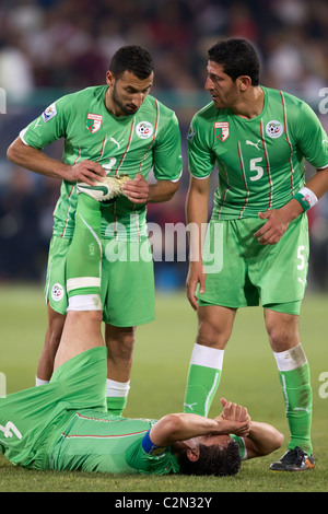 Algeria i giocatori Nadir Belhadj (3) e Rafik Halliche (5) assistere il compagno di squadra antera Yahia (4) in un 2010 World Cup match contro gli USA. Foto Stock