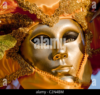 Una donna che indossa una maschera d'oro durante il carnevale di Venezia, Venezia, Italia Foto Stock